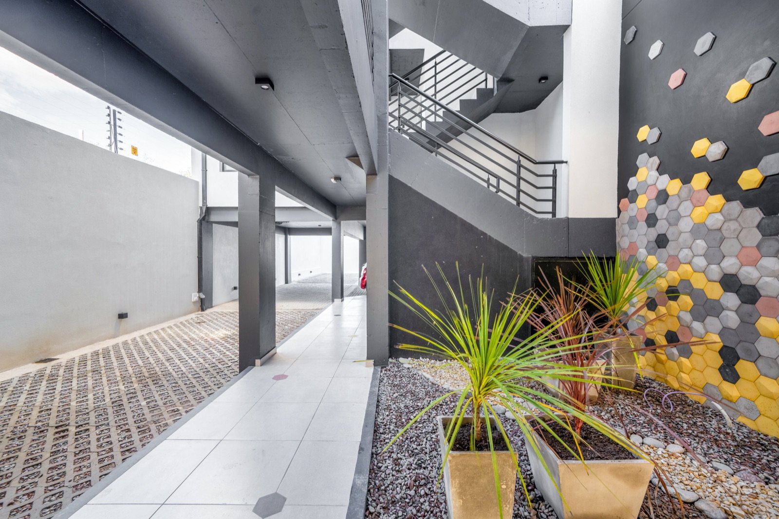 Hall de acceso, con escalera y muro revestido en hexágonos