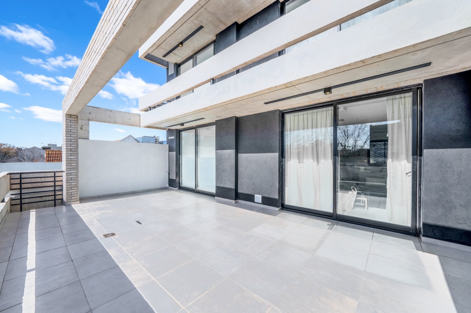 Terraza con ventanales y solado de porcelanato